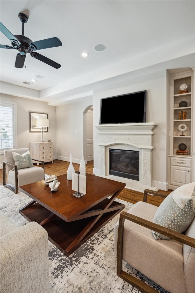 3310 Glen Haven Blvd, Houston, TX 77025 - living room with arched walkways, ceiling fan, wood finished floors, recessed lighting, and a glass covered fireplace