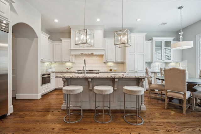 3310 Glen Haven Blvd, Houston, TX 77025 - kitchen featuring white cabinetry, backsplash, dark wood-style floors, light stone countertops, and recessed lighting