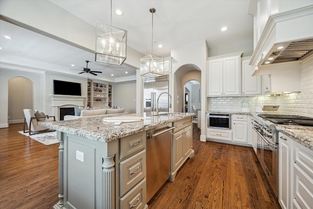 3310 Glen Haven Blvd, Houston, TX 77025 - kitchen featuring high end appliances, arched walkways, a ceiling fan, a fireplace, and recessed lighting