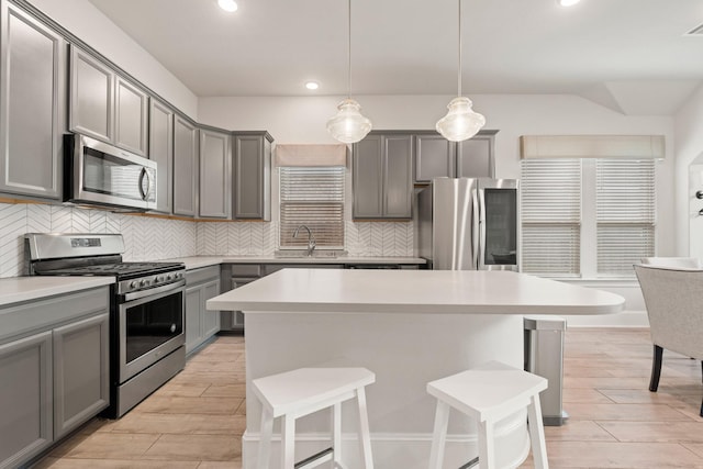 6023 Dovetail Cliff Ct, Katy, TX 77493 - kitchen featuring stainless steel appliances, gray cabinetry, a breakfast bar, and recessed lighting
