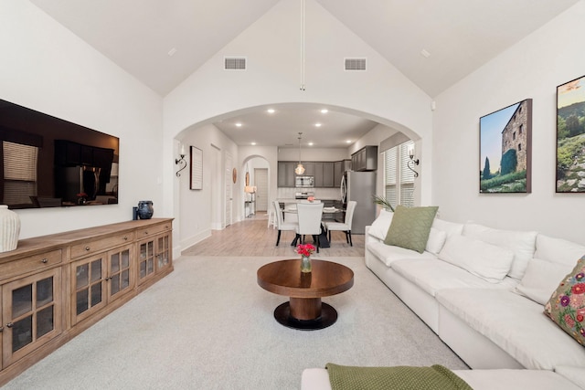 6023 Dovetail Cliff Ct, Katy, TX 77493 - living room with arched walkways, high vaulted ceiling, recessed lighting, and light wood-type flooring