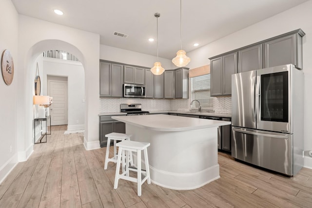 6023 Dovetail Cliff Ct, Katy, TX 77493 - kitchen featuring appliances with stainless steel finishes, gray cabinets, a kitchen island, and recessed lighting