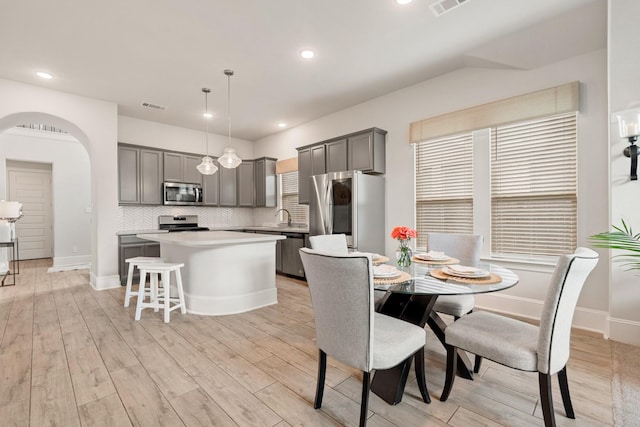 6023 Dovetail Cliff Ct, Katy, TX 77493 - dining space with light wood-style flooring, arched walkways, and recessed lighting