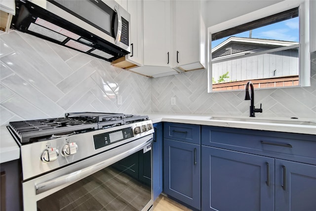 9622 Clanton St, Houston, TX 77080 - kitchen featuring stainless steel appliances, blue cabinets, light countertops, and decorative backsplash