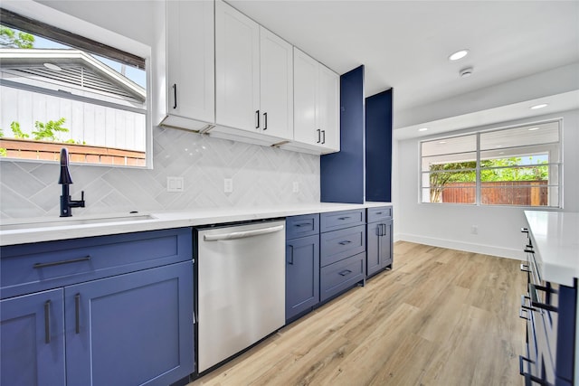 9622 Clanton St, Houston, TX 77080 - kitchen featuring stainless steel dishwasher, blue cabinetry, white cabinetry, light countertops, and backsplash