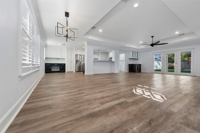 9210 Rangely Dr, Houston, TX 77055 - unfurnished living room with a tray ceiling, a chandelier, ceiling fan, light wood-style floors, and recessed lighting