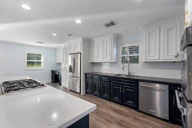 9210 Rangely Dr, Houston, TX 77055 - kitchen with stainless steel appliances, white cabinets, crown molding, dark stone countertops, and dark wood finished floors