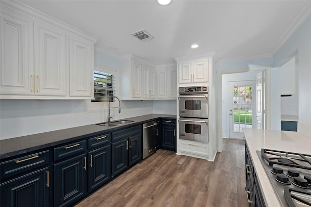 9210 Rangely Dr, Houston, TX 77055 - kitchen featuring stainless steel appliances, white cabinets, wood finished floors, recessed lighting, and ornamental molding