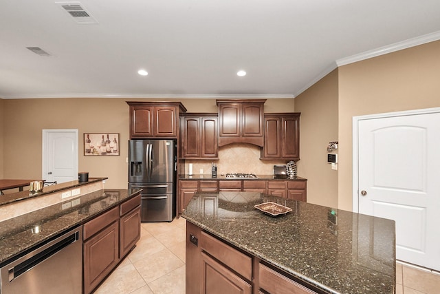 13723 Playa Lucia Ct, Houston, TX 77044 - kitchen with stainless steel appliances, tasteful backsplash, ornamental molding, light tile patterned floors, and dark stone counters