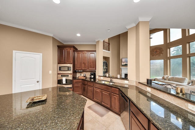 13723 Playa Lucia Ct, Houston, TX 77044 - kitchen featuring appliances with stainless steel finishes, ornamental molding, recessed lighting, dark stone counters, and light tile patterned floors