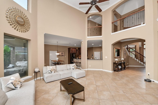 13723 Playa Lucia Ct, Houston, TX 77044 - living area with arched walkways, light tile patterned floors, ceiling fan, a high ceiling, and stairway