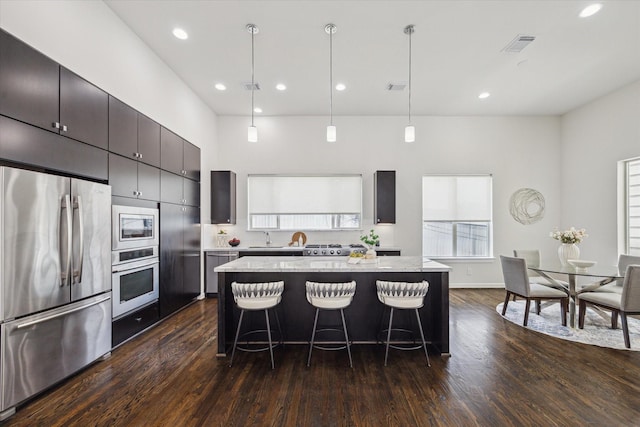 805 Sandman St, Houston, TX 77007 - kitchen featuring stainless steel appliances, a breakfast bar, a center island, dark wood finished floors, and recessed lighting