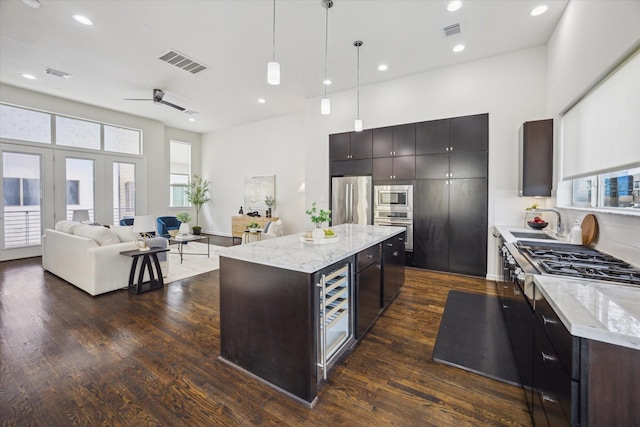 805 Sandman St, Houston, TX 77007 - kitchen with appliances with stainless steel finishes, dark wood-style flooring, a high ceiling, pendant lighting, and a center island