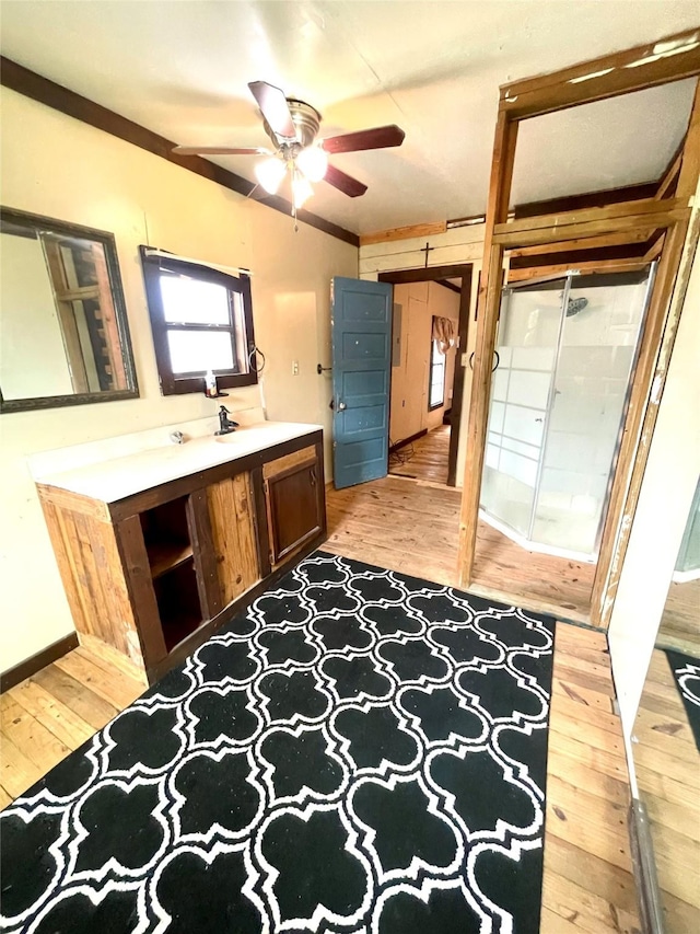 206 E Rogers St, Ganado, TX 77962 - bathroom with wood-type flooring, vanity, a ceiling fan, and a shower stall
