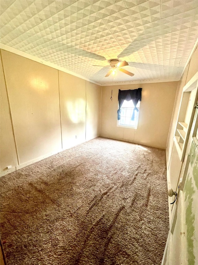 206 E Rogers St, Ganado, TX 77962 - empty room featuring carpet, ornamental molding, and a ceiling fan