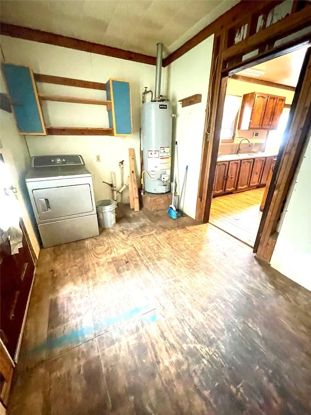 206 E Rogers St, Ganado, TX 77962 - laundry room featuring water heater, washer / dryer, light wood-style floors, and cabinet space