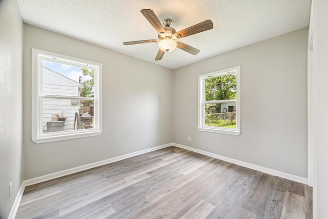 210 Laurel St, Lake Jackson, TX 77566 - unfurnished room featuring healthy amount of natural light, wood finished floors, ceiling fan, and a textured ceiling