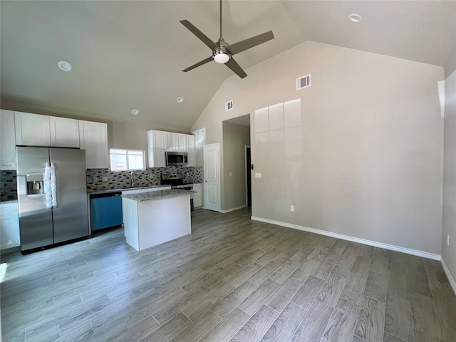 16897 W Alderson, Montgomery, TX 77316 - kitchen featuring stainless steel appliances, a ceiling fan, a kitchen island, high vaulted ceiling, and white cabinets