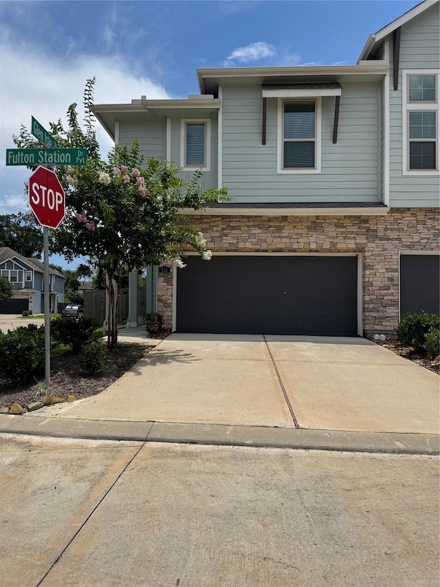 214 Fulton Station Dr, Houston, TX 77009 - view of front of home with a garage, stone siding, and driveway