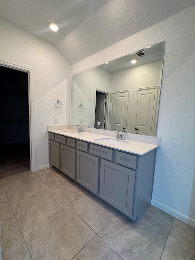 214 Fulton Station Dr, Houston, TX 77009 - bathroom featuring double vanity, vaulted ceiling, and tile patterned flooring