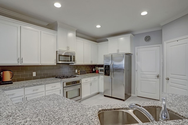 1113 Peden St Unit A, Houston, TX 77006 - kitchen featuring stainless steel appliances, ornamental molding, white cabinets, backsplash, and light stone countertops