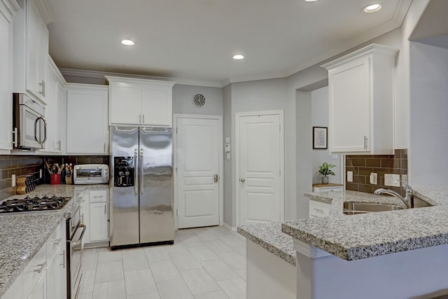 1113 Peden St Unit A, Houston, TX 77006 - kitchen featuring stainless steel appliances, white cabinets, backsplash, recessed lighting, and ornamental molding