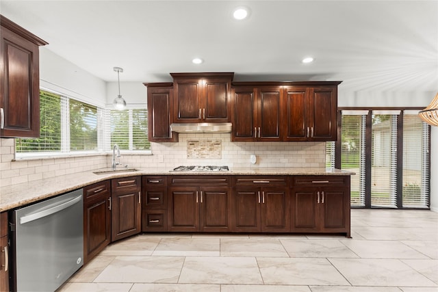 18910 Casper Dr, Spring, TX 77373 - kitchen with stainless steel appliances, under cabinet range hood, light marble finish flooring, backsplash, and recessed lighting