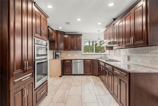 18910 Casper Dr, Spring, TX 77373 - kitchen with stainless steel appliances, recessed lighting, light marble finish flooring, light stone countertops, and tasteful backsplash