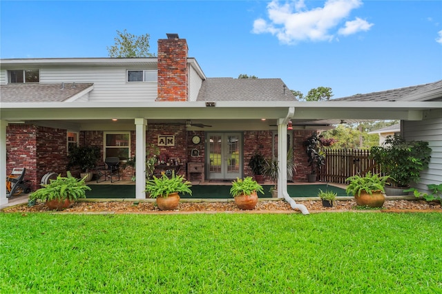 18910 Casper Dr, Spring, TX 77373 - rear view of house featuring french doors, a lawn, roof with shingles, a chimney, and brick siding