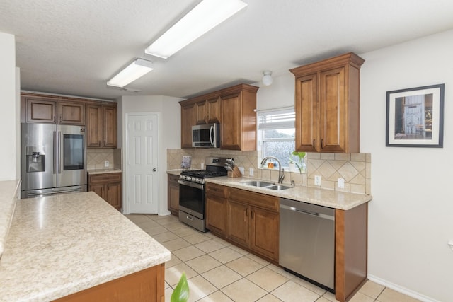 14903 Sugar Sweet Dr, Sugar Land, TX 77498 - kitchen with appliances with stainless steel finishes, light countertops, decorative backsplash, light tile patterned floors, and brown cabinets