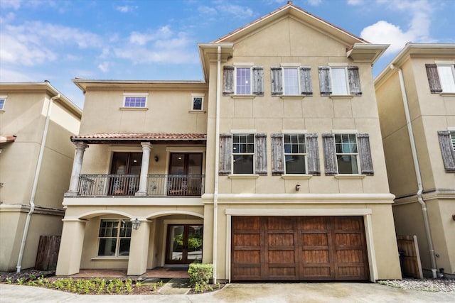 431 Jackson Hill St, Houston, TX 77007 - back of house featuring stucco siding, a balcony, a garage, french doors, and driveway