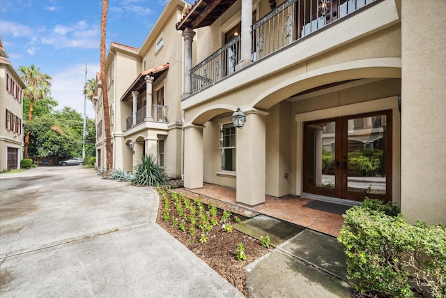 431 Jackson Hill St, Houston, TX 77007 - entrance to property with french doors, stucco siding, a balcony, and driveway