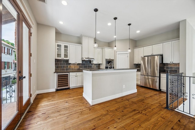 431 Jackson Hill St, Houston, TX 77007 - kitchen featuring stainless steel appliances, wine cooler, dark countertops, backsplash, and hardwood / wood-style floors