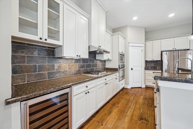 431 Jackson Hill St, Houston, TX 77007 - kitchen featuring wine cooler, appliances with stainless steel finishes, under cabinet range hood, white cabinetry, and recessed lighting