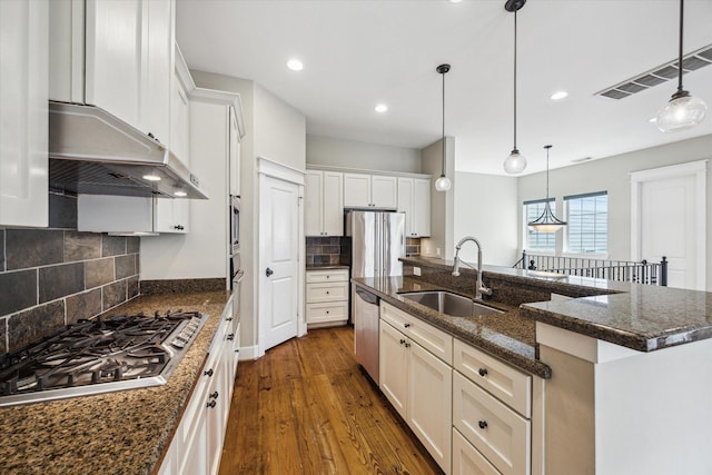 431 Jackson Hill St, Houston, TX 77007 - kitchen with appliances with stainless steel finishes, under cabinet range hood, dark wood finished floors, recessed lighting, and an island with sink