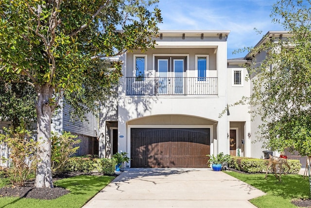 7706 Janak Dr Unit C, Houston, TX 77055 - view of front of property featuring a balcony, stucco siding, driveway, and an attached garage