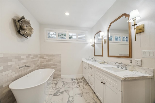2022 Chaparral Dr, Houston, TX 77043 - bathroom with marble look tile flooring, a freestanding tub, double vanity, and recessed lighting
