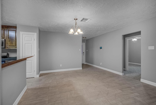 2440 Olympia Dr, West Columbia, TX 77486 - unfurnished dining area with a chandelier and a textured ceiling