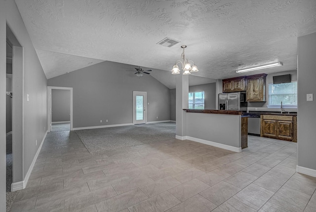 2440 Olympia Dr, West Columbia, TX 77486 - kitchen featuring stainless steel appliances, dark countertops, a textured ceiling, a chandelier, and lofted ceiling