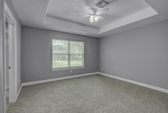 2440 Olympia Dr, West Columbia, TX 77486 - carpeted empty room featuring a tray ceiling, a textured ceiling, and a ceiling fan