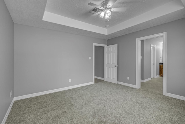 2440 Olympia Dr, West Columbia, TX 77486 - unfurnished bedroom with a textured ceiling, carpet floors, a raised ceiling, and ceiling fan