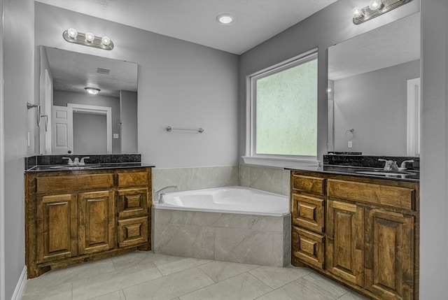 2440 Olympia Dr, West Columbia, TX 77486 - bathroom featuring two vanities, a bath, and marble finish flooring
