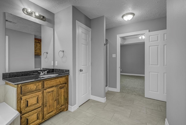 2440 Olympia Dr, West Columbia, TX 77486 - full bathroom featuring a textured ceiling, vanity, and a shower stall