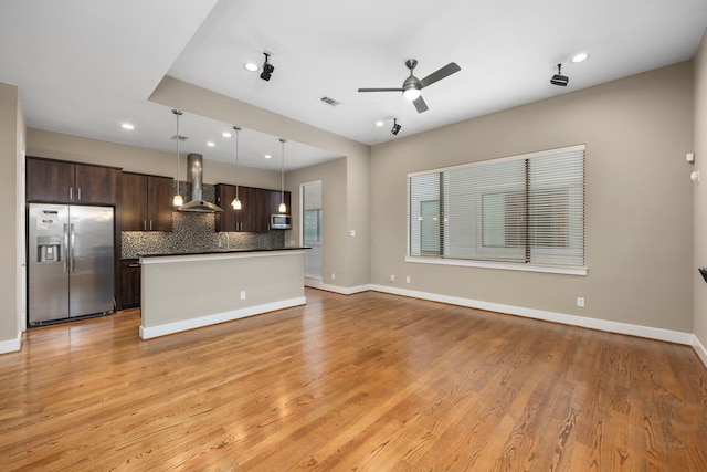 1801 Radcliffe St, Houston, TX 77007 - kitchen with stainless steel appliances, wall chimney range hood, dark brown cabinetry, dark countertops, and backsplash