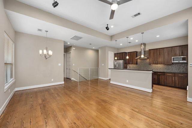 1801 Radcliffe St, Houston, TX 77007 - kitchen with appliances with stainless steel finishes, wall chimney range hood, dark countertops, a chandelier, and dark brown cabinets