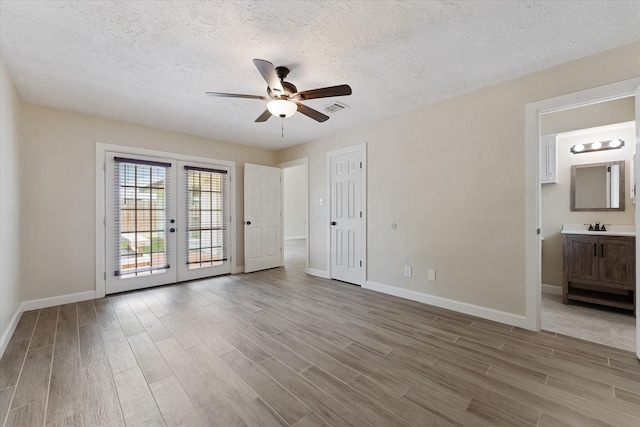 21507 Glenbranch Dr, Spring, TX 77388 - unfurnished bedroom with access to outside, wood finished floors, french doors, a textured ceiling, and connected bathroom