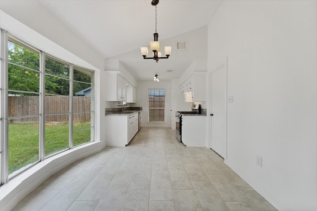 21507 Glenbranch Dr, Spring, TX 77388 - kitchen with stainless steel gas range oven, lofted ceiling, dark countertops, white cabinets, and a chandelier