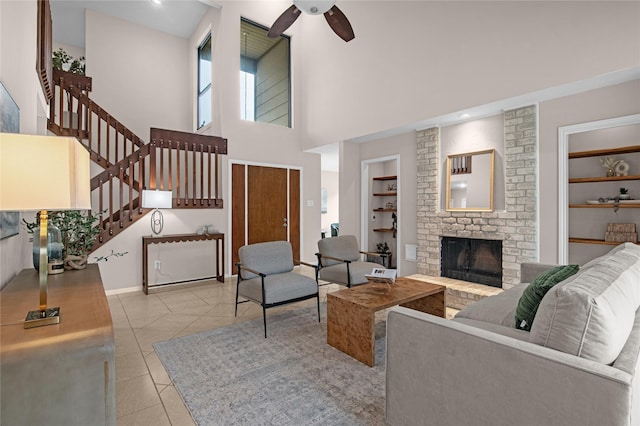 16606 Neumann Dr, Houston, TX 77058 - living room with a ceiling fan, built in features, a fireplace, light tile patterned floors, and a towering ceiling