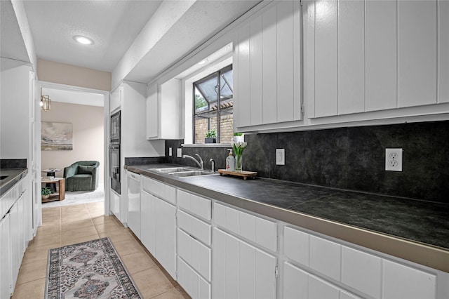 16606 Neumann Dr, Houston, TX 77058 - kitchen featuring decorative backsplash, white cabinetry, dark countertops, light tile patterned floors, and oven