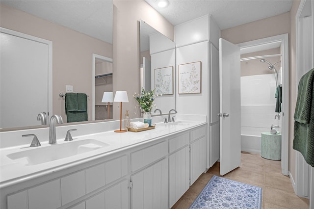16606 Neumann Dr, Houston, TX 77058 - bathroom featuring double vanity, bathtub / shower combination, a textured ceiling, and tile patterned flooring